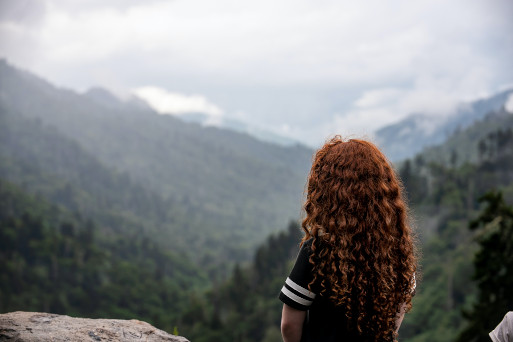 Red Haired female overlooking a Mountain Scene representing Real Estate Acreage and Land Opportunities in Tennessee
